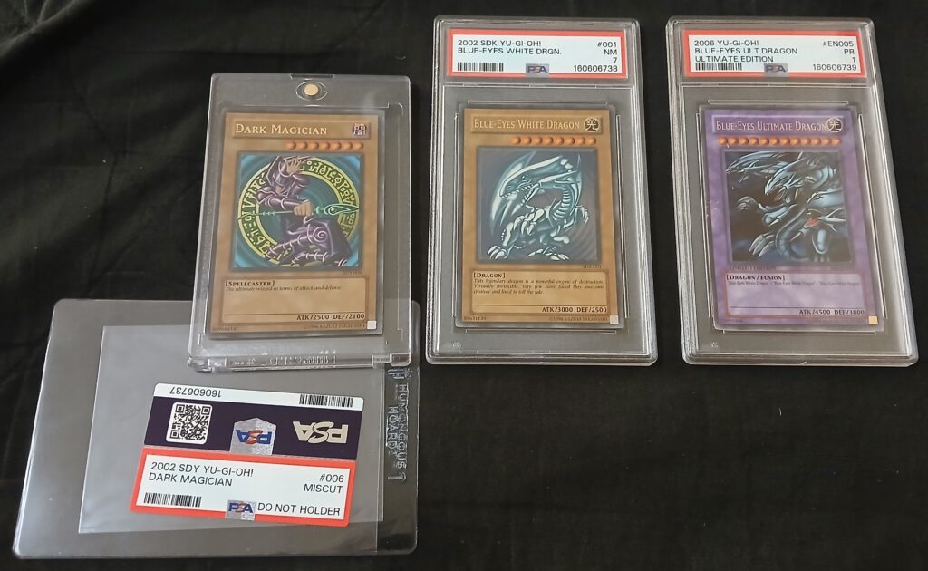 Dark Magician (SDY-006) - N8 MISCUT, Blue-Eyes White Dragon (SDK-001) - PSA NEAR MINT 7, Blue-Eyes Ultimate Dragon (JMP-EN005) - PSA POOR 1 (August 8, 2026)